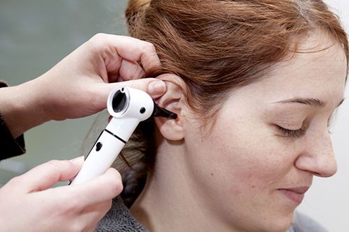 Woman having her ear examined
