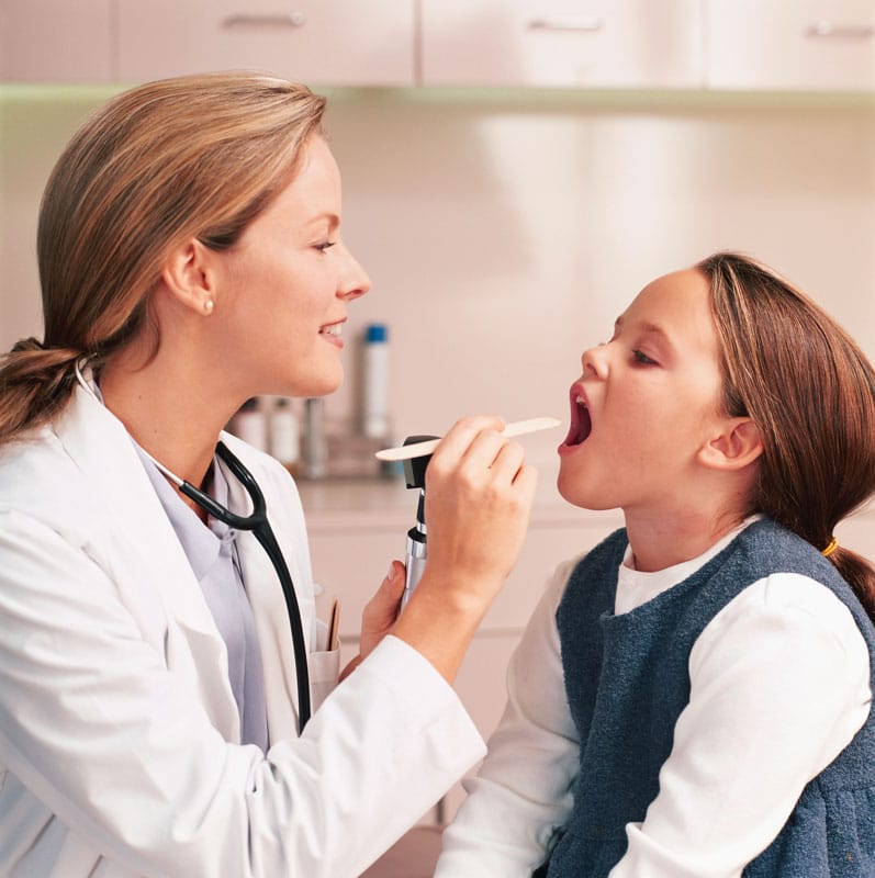 Young girl receiving an oral exam from doctor