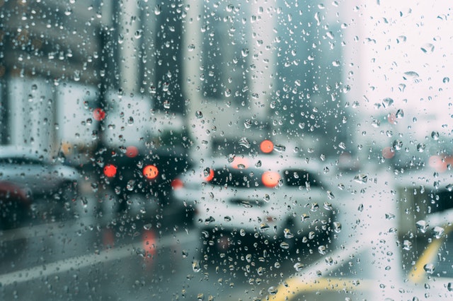 Rain covered window looking out to city traffic