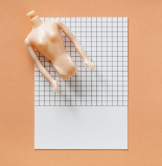 A doll torso on top of graph paper 