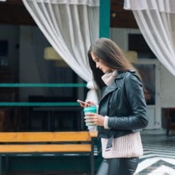 woman walking in public looking at cell phone