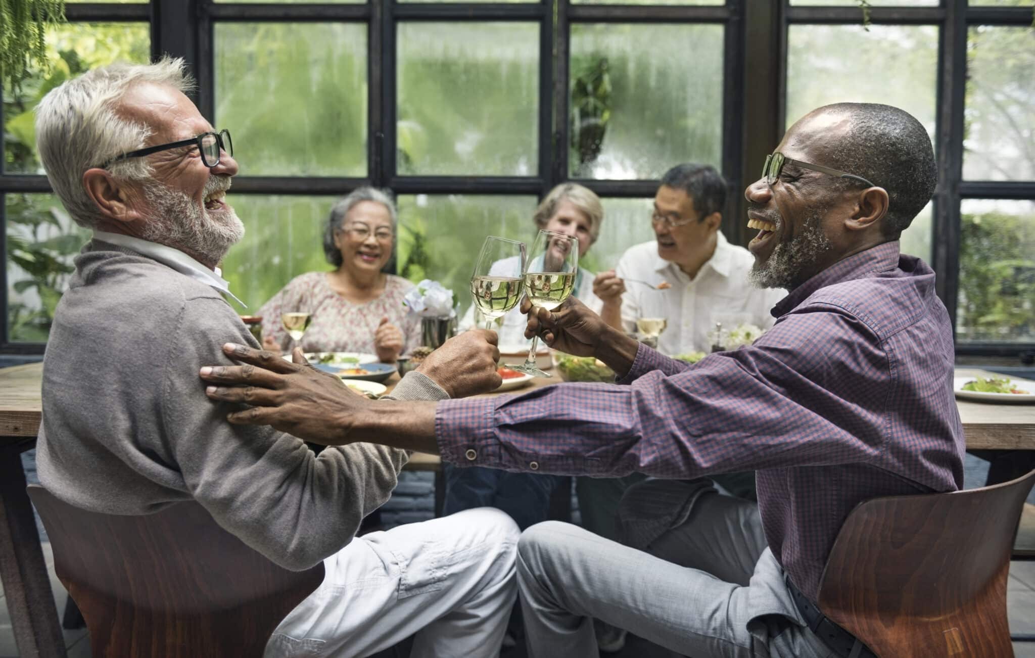 Group of older friends conversing at a dinner party.