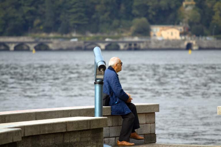 Man sitting on a ledge near the river