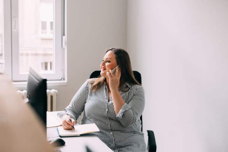 Woman sitting at her desk talking on the phone