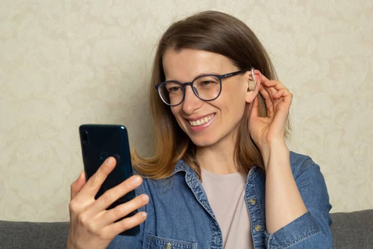 Woman talks on the phone with hearing aid