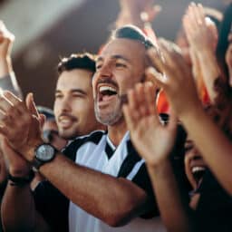 Group of men and women cheering their national team.