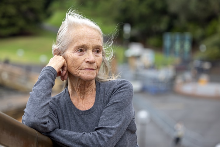 Portrait of senior woman outdoor with hand on chin looking away, background with copy space Portrait of senior woman outdoor with hand on chin looking away, background with copy space, full frame horizontal composition
